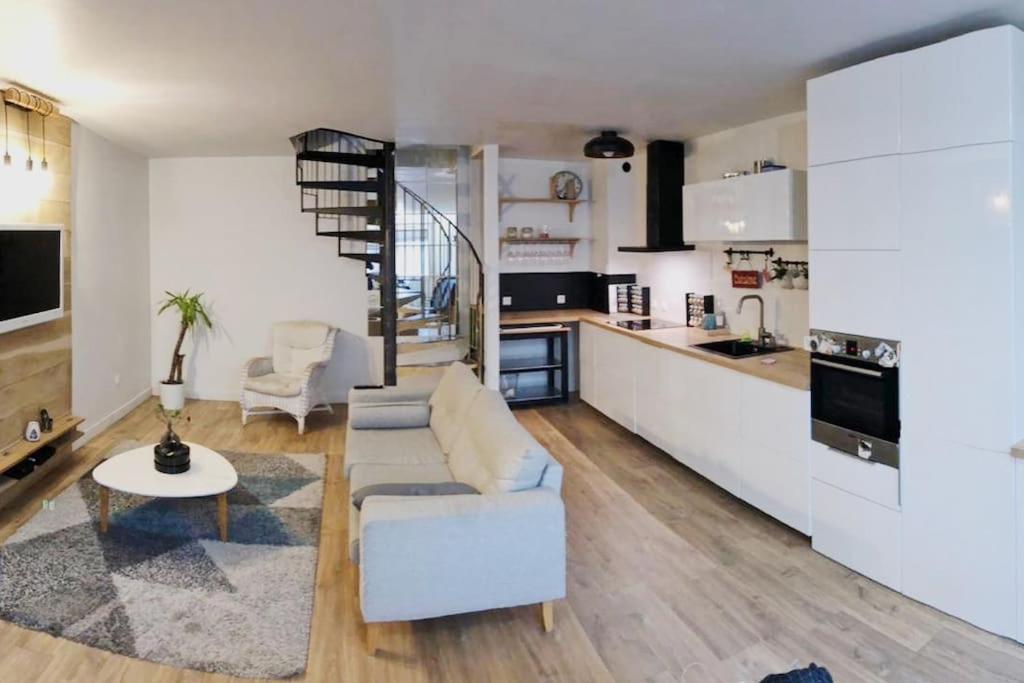 a living room with a couch and a kitchen at Maison calme et cosy aux portes de Paris in Ivry-sur-Seine