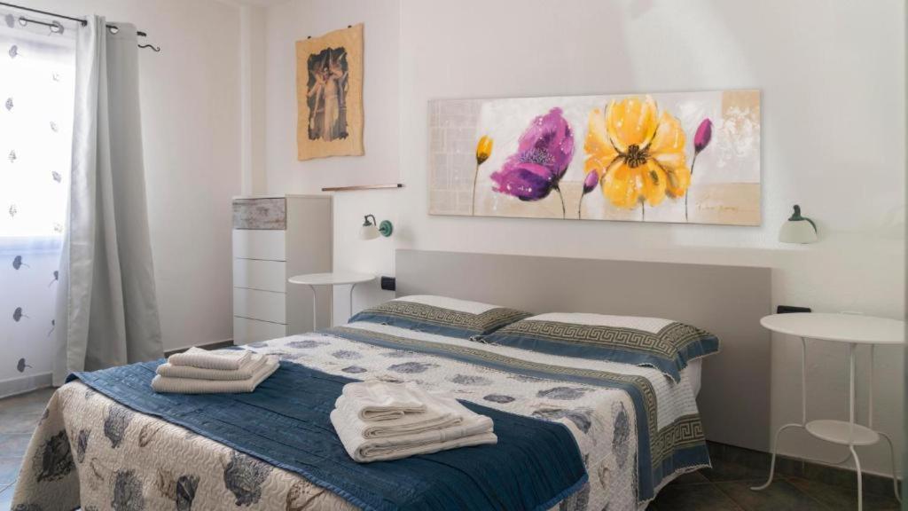 - une chambre avec un lit et une peinture murale dans l'établissement Cala Gonone house, à Cala Gonone