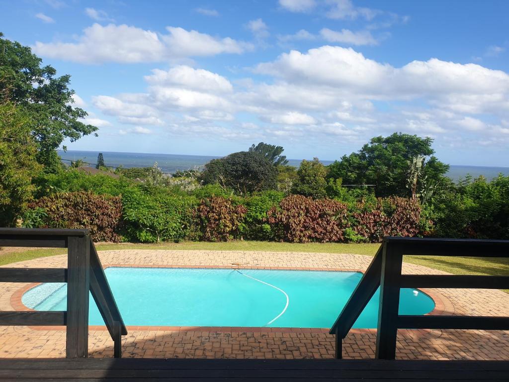 a swimming pool with a view of the ocean at Grace Avenue Townhouse in Port Edward