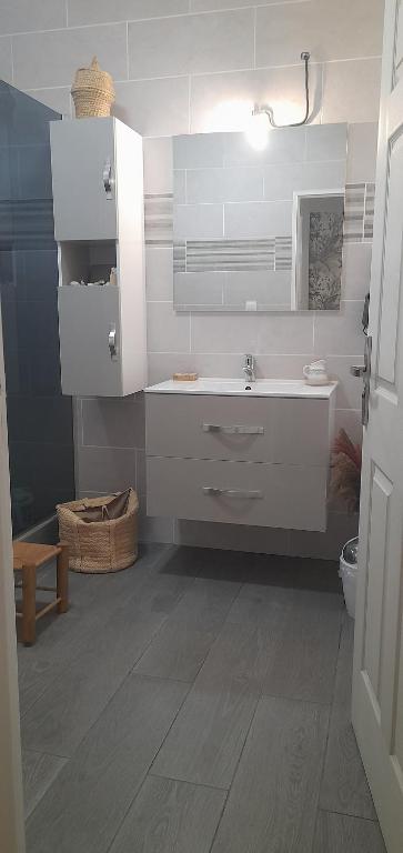 a white bathroom with a sink and a toilet at Chambre diamants in Saint-Pierre