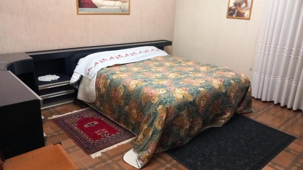 ein Schlafzimmer mit einem Bett mit einer Decke darauf in der Unterkunft Comodissimo vicino a Venezia in Campagna Lupia