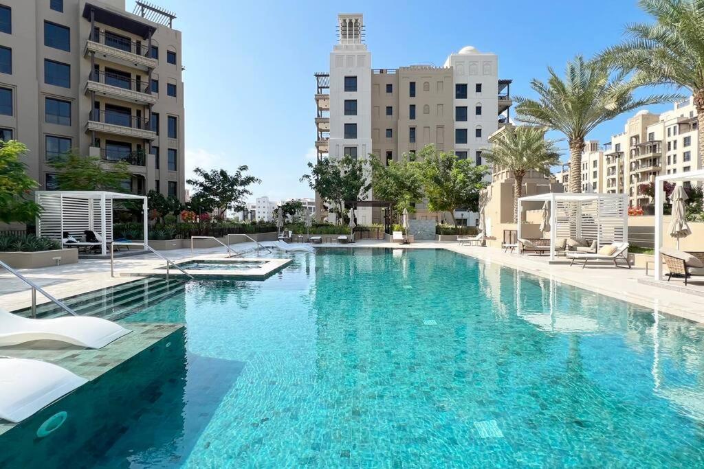 a large swimming pool with blue water in a city at Post Modern Near Burj Al Arab in Dubai