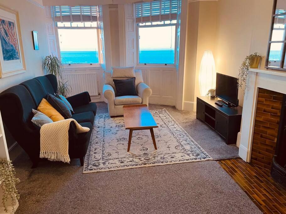 ein Wohnzimmer mit einem Sofa, Stühlen und einem Tisch in der Unterkunft Seaside Getaway in Brighton & Hove