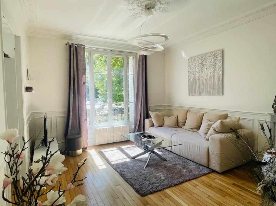 uma sala de estar branca com um sofá e uma mesa em JO 2024/ 10min Stade de France em Enghien-les-Bains