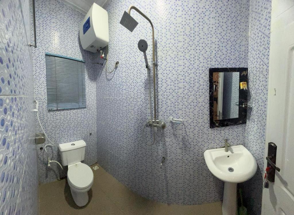 a bathroom with a shower and a toilet and a sink at Owtee’s Apartments in Port Harcourt