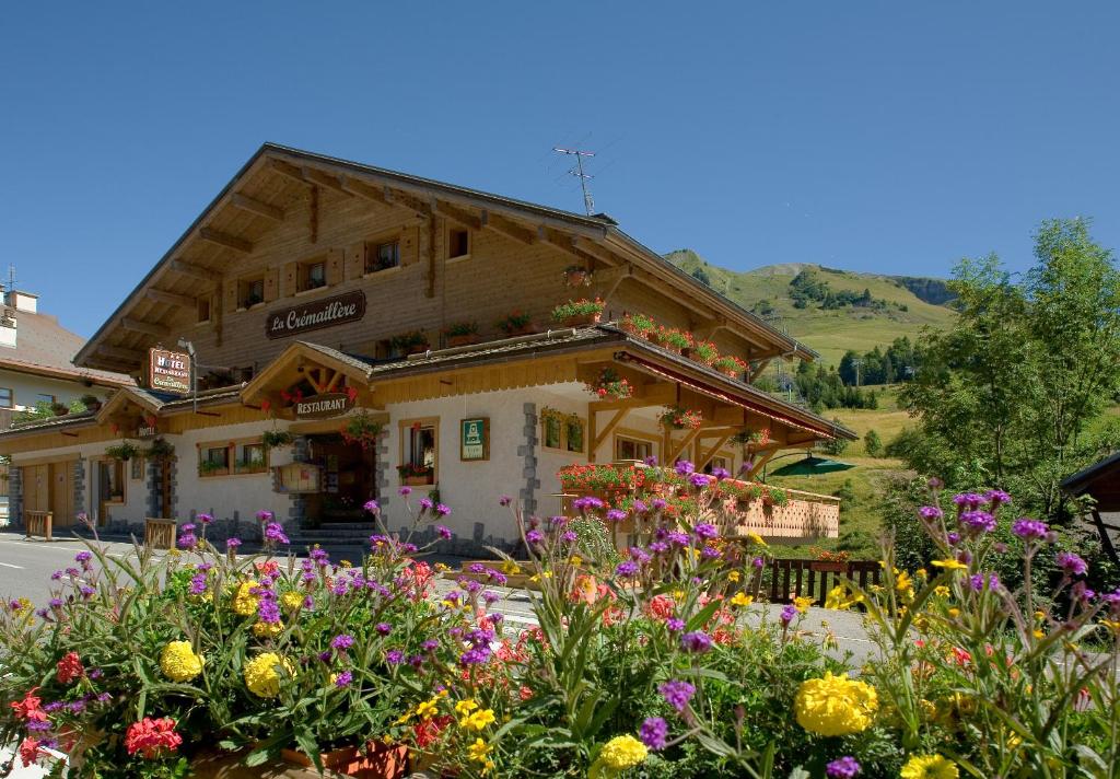 a building with a bunch of flowers in front of it at Hotel La Crémaillère in Le Grand-Bornand