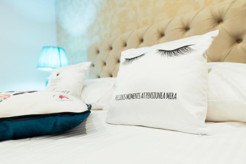 a bed with a pillow with a eyelashnetworkresponseamineamineamine at Pensiunea Mira in Bîrlad