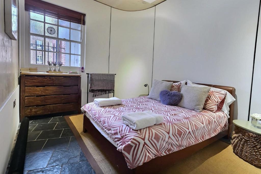 a bedroom with a bed with two pillows on it at 1 bedroom flat near Russel Square in London