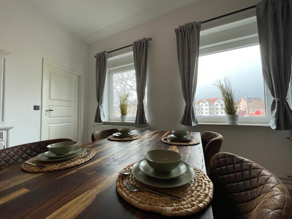 mesa de comedor con 2 sillas y 2 ventanas en Ferienwohnung Seegras, en Emden