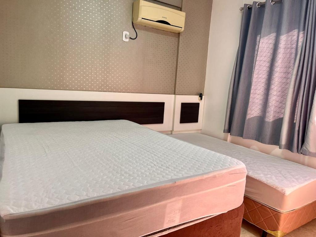 a small bedroom with two beds and a window at Sapphire Tower CTC 601-B in Caldas Novas