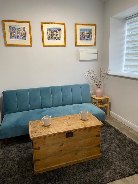 a living room with a blue couch and a coffee table at The Old Barn one bedroom apartment in Overton in Overton