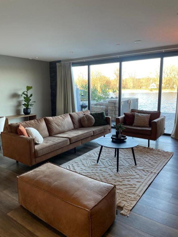 uma sala de estar com um sofá e uma mesa em Waterside Voorthuizen em Voorthuizen