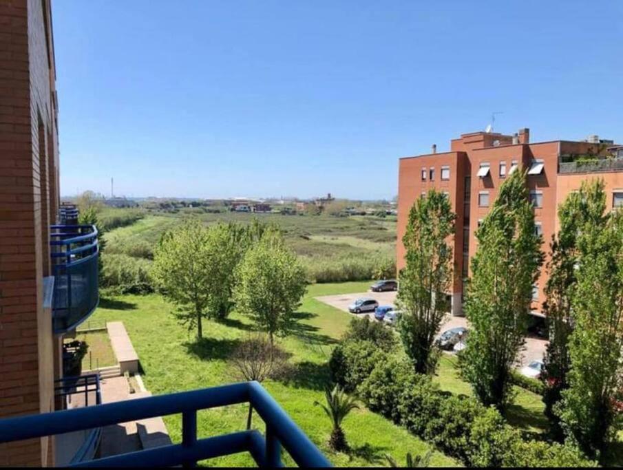 a balcony with a view of a park and buildings at Ostia Sunsets • Home near Rome and Airport in Lido di Ostia