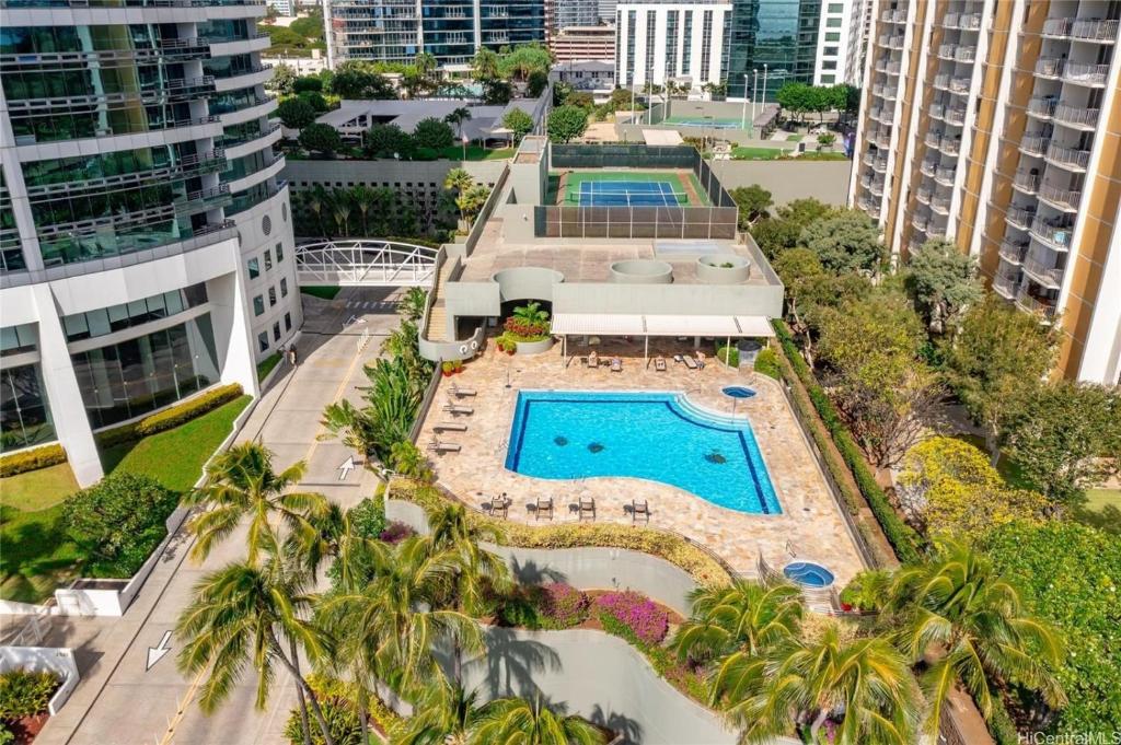 an aerial view of a resort with a pool and palm trees at Moana Luxury Residence in Honolulu