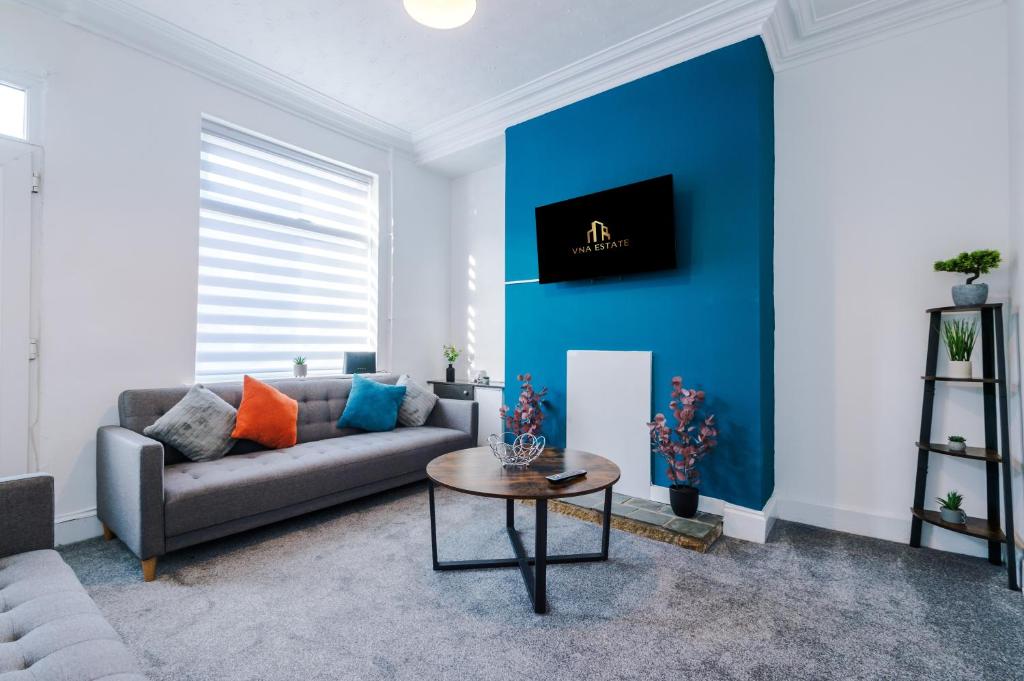 a living room with a couch and a blue wall at Entire house in Dukinfield in Dukinfield