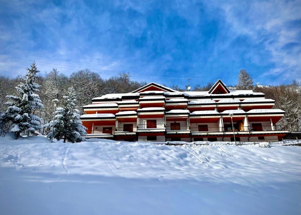 a building covered in snow with snow covered trees at La Sorgente - Immersi nella natura in Limone Piemonte