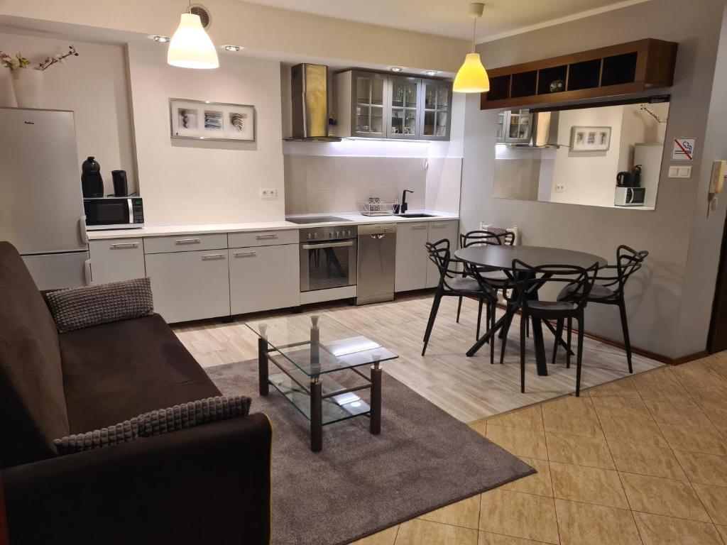 a kitchen and living room with a table and chairs at Wigwam Apartament 6-osobowy in Sopot
