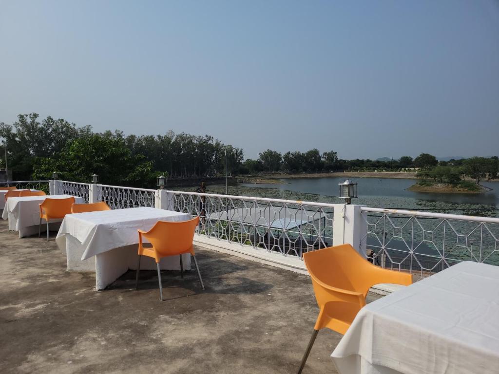 Hotel Lakeside & Hostel في خاجوراهو: صف من الطاولات والكراسي على الشرفة