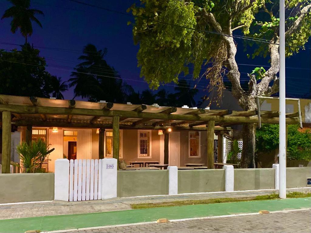 a house with a white fence in front of it at A casa do vizinho in Itaparica