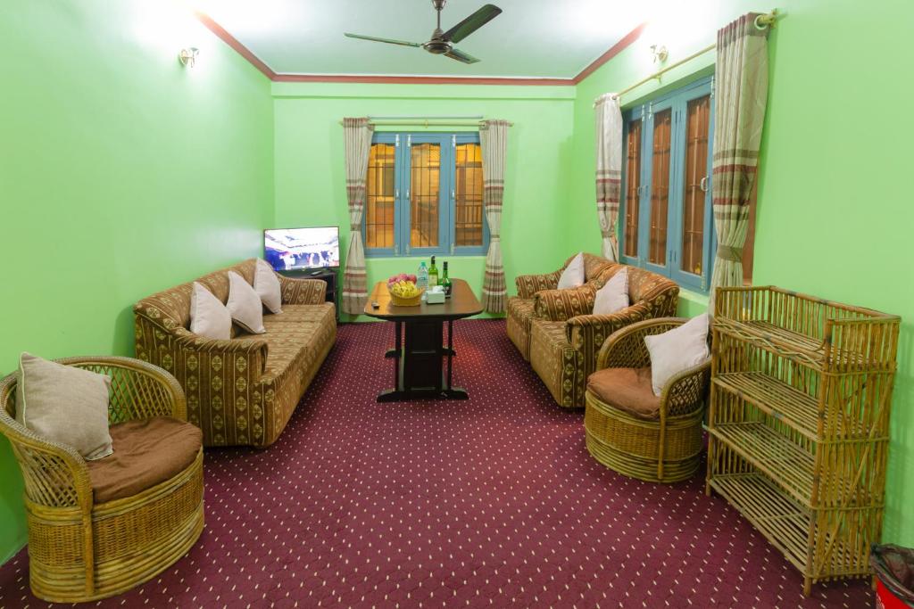 un soggiorno con divani, sedie e un tavolo di Paradise Boutique Hotel a Pokhara