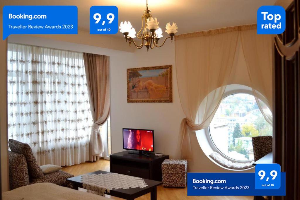 un soggiorno con TV e finestra di Sunny apartment in the city Center a Truskavec'