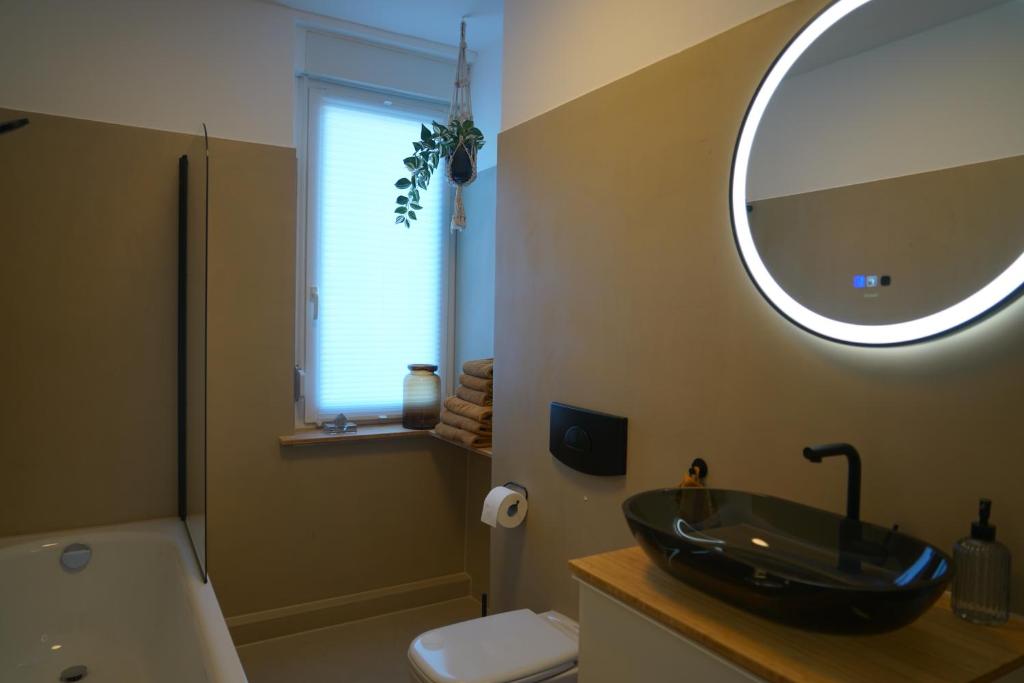 uma casa de banho com um lavatório preto e um espelho em Apartment Carla em Senftenberg