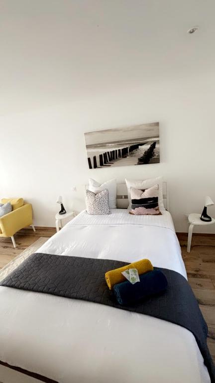 um quarto com uma grande cama branca num quarto em Chambre le Petit Olivier em Arles