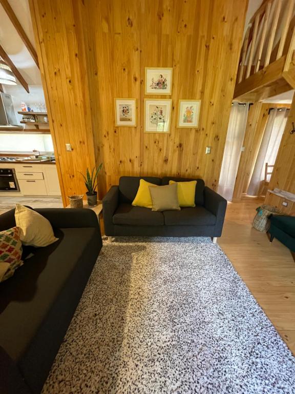 a living room with a black couch and a rug at Refugio Río Roberto in Villa Santa Lucía