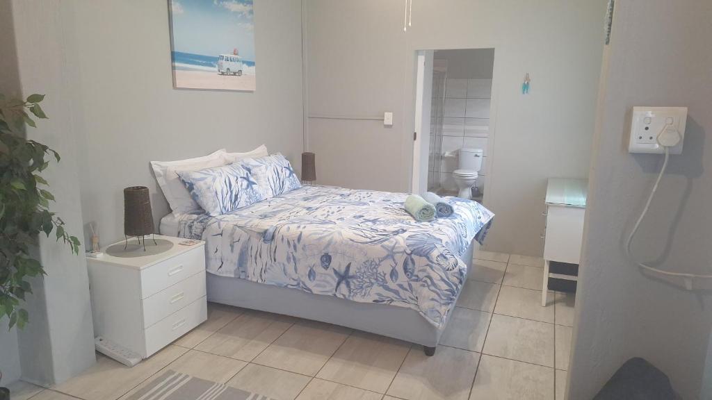 a small bedroom with a bed and a bathroom at The Starfish Cottage in Scottburgh