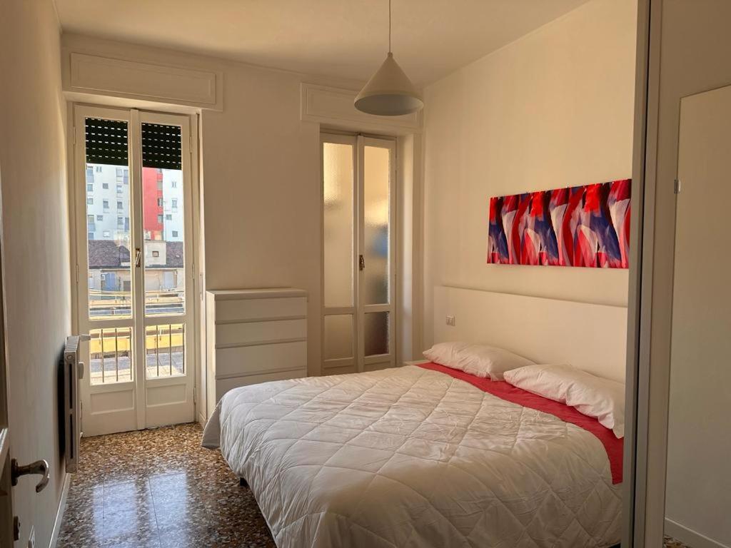 una camera da letto con un letto e un dipinto sul muro di Kibilù - Via Lomellina MM Argonne - Linate Airport a Milano