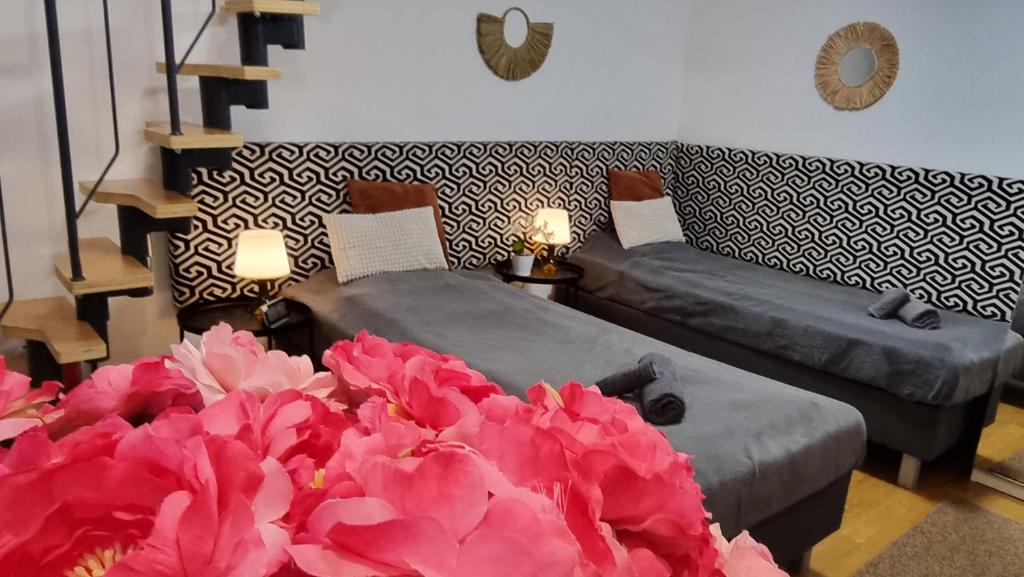 a living room with two beds and pink flowers at Bercsényi apartments - close to the Gellért Thermal Bath in Budapest