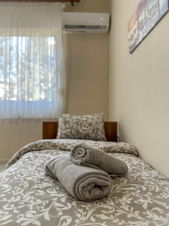 a bed with two towels on top of it at Ground Apartment AXD in Alexandroupoli