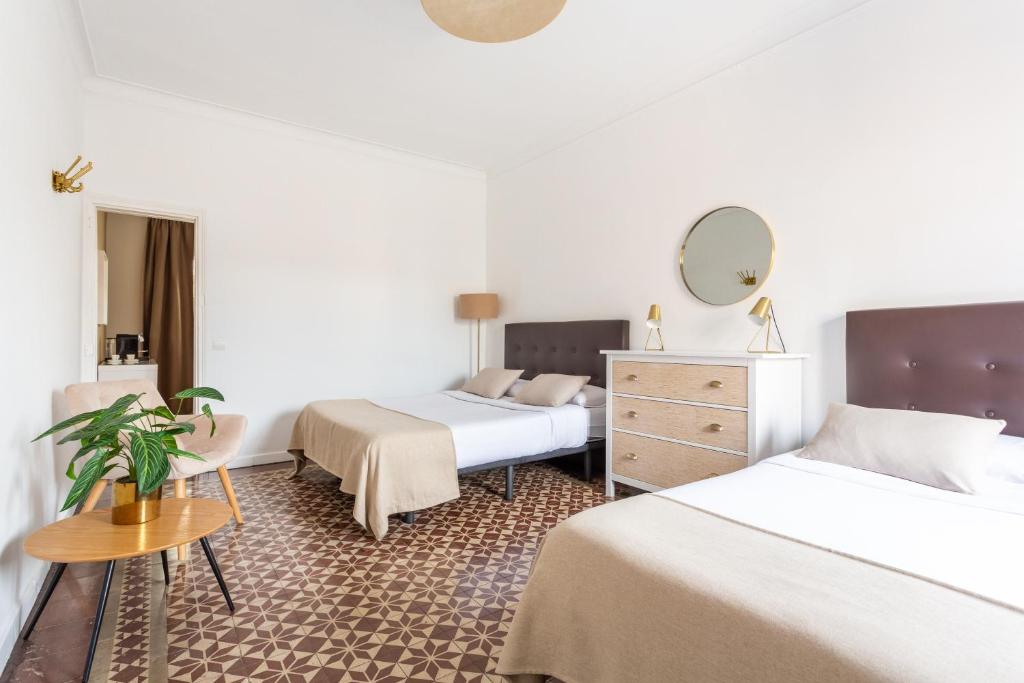 Habitación de hotel con 2 camas y espejo en Sunny rooms bcn, en Barcelona