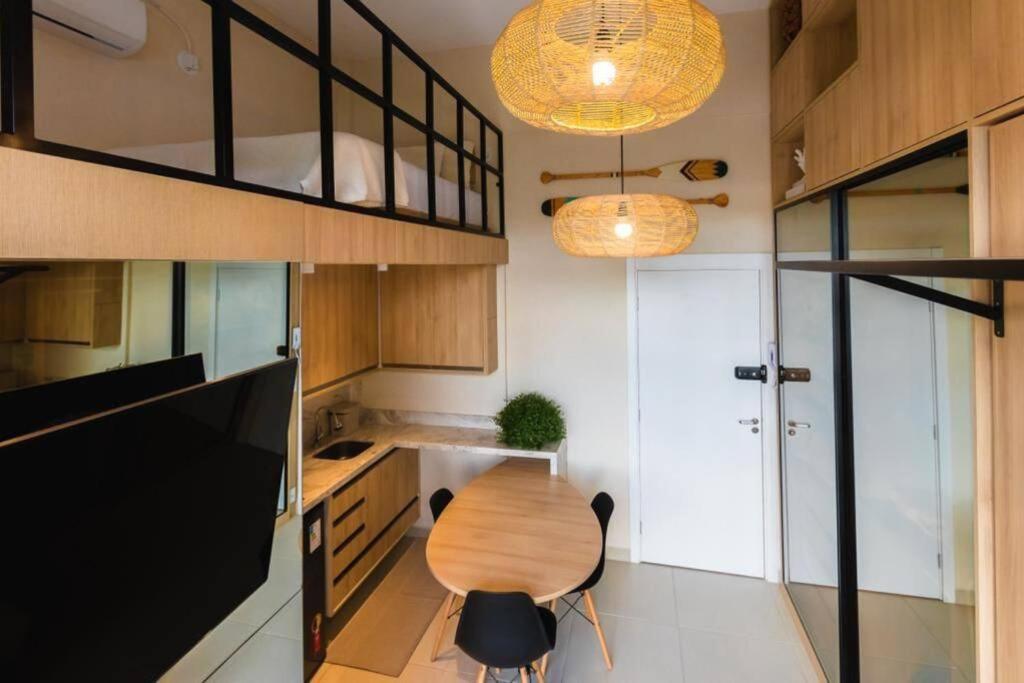 uma cozinha com uma mesa de madeira e uma cadeira em Duplex Luxo Vista Parque Bariguí em Curitiba