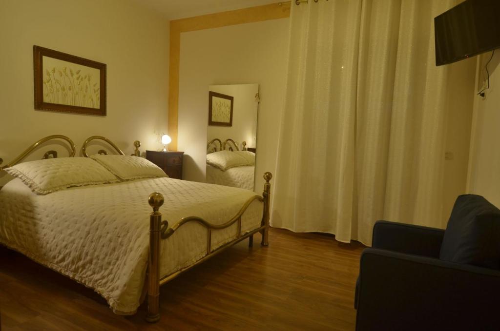 1 dormitorio con cama, sofá y espejo en Appartamento Val d'Orcia Patri en Piancastagnaio