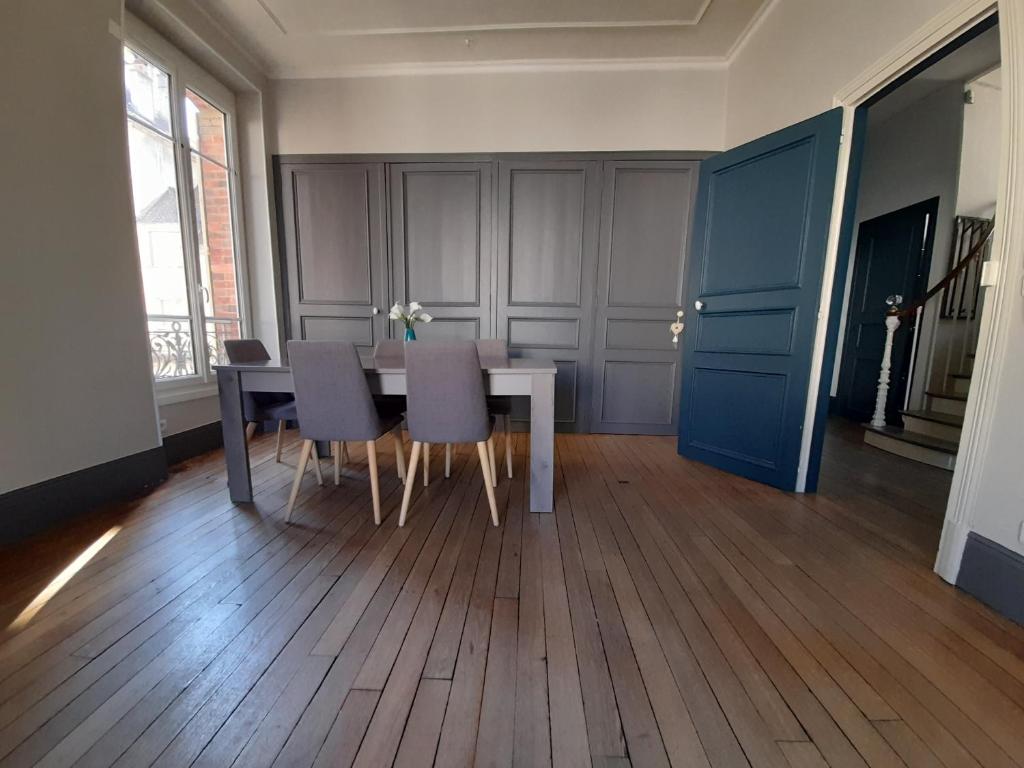 uma sala de jantar com uma mesa branca e cadeiras em Magnifique maison avec terrasse em Château-Thierry