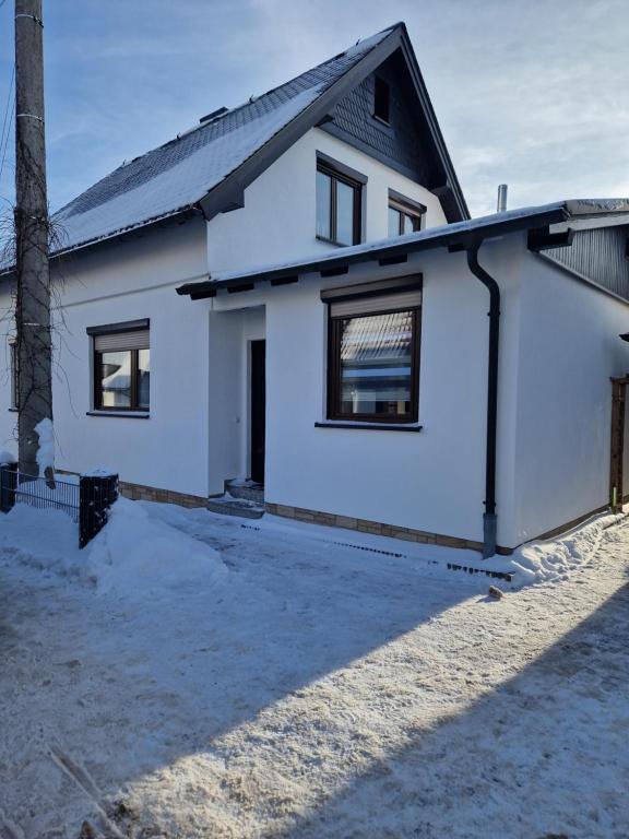 倫斯泰格地區施米德費爾德的住宿－Ferienwohnung am Eisenberg，黑色屋顶的白色房子
