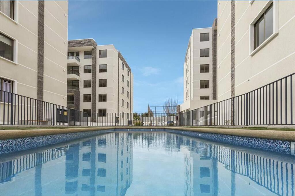 a swimming pool in the middle of two buildings at Genial Ubicación, cerca de todo! in La Serena