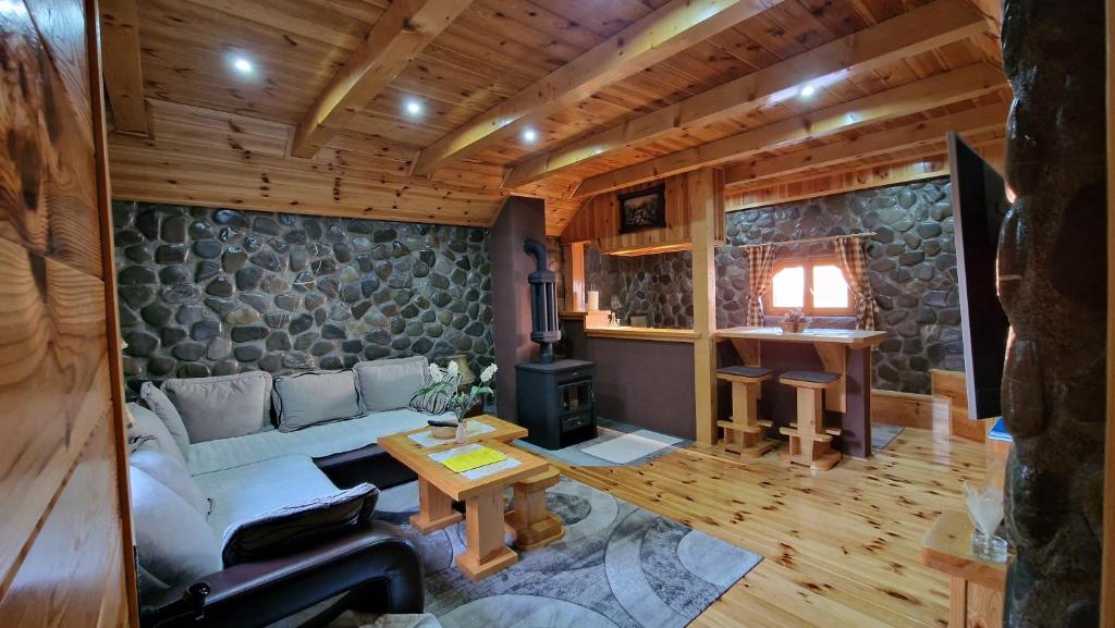 a living room with a couch and a stove at Stone Lodge 1 in Kolašin