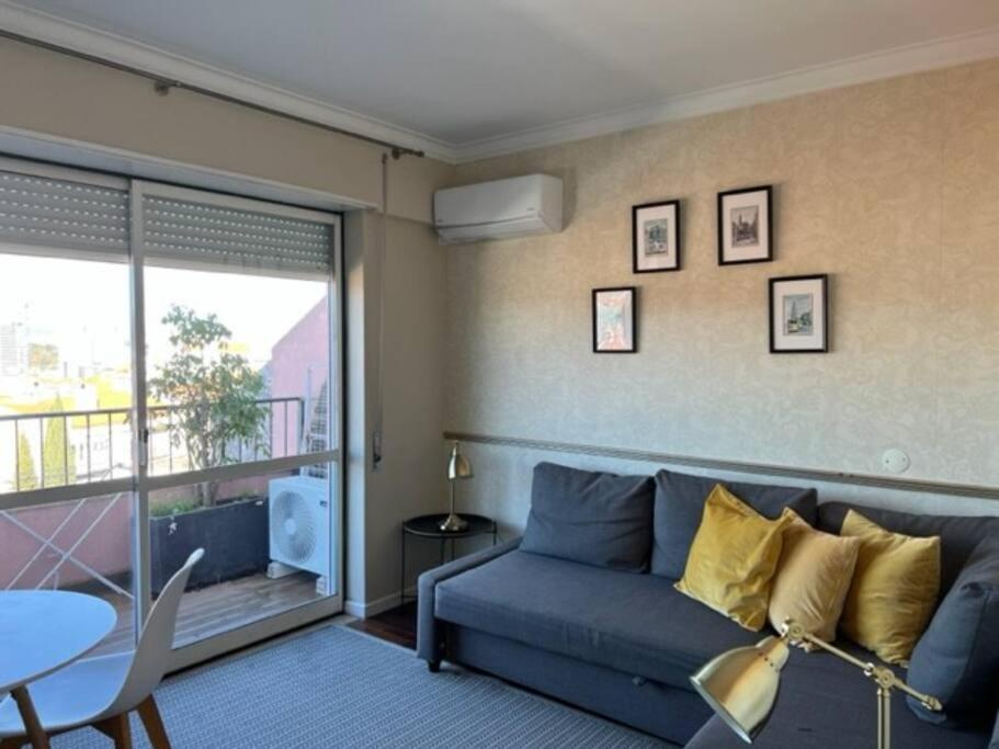 - un salon avec un canapé bleu et une table dans l'établissement NEW Monsanto View Charming Apartment @ Campolide - 3B, à Lisbonne