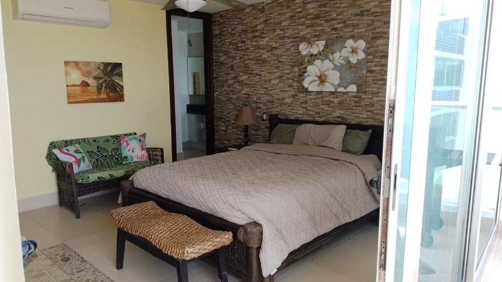 1 dormitorio con cama y pared de ladrillo en PH SERENA, en Nueva Gorgona