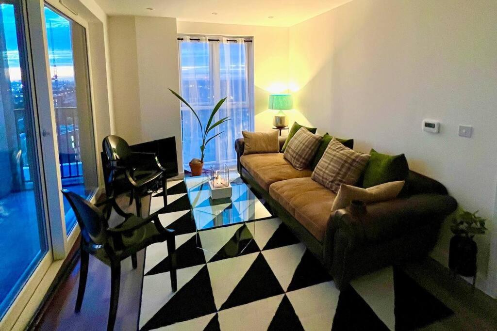 uma sala de estar com um sofá e uma mesa de vidro em Modern 14th Floor 1or2-Bed Flat em Dagenham