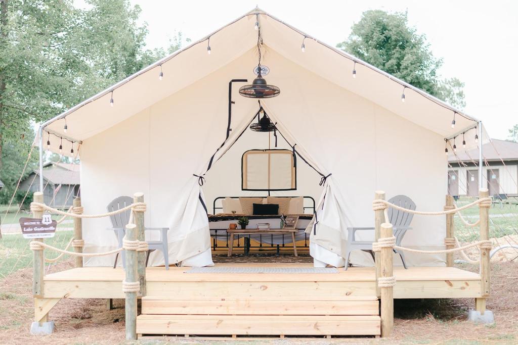 una tienda de campaña para una boda con dos bancos en XLg Porch Deluxe glamping tents @ Lake Guntersville State Park, en Guntersville
