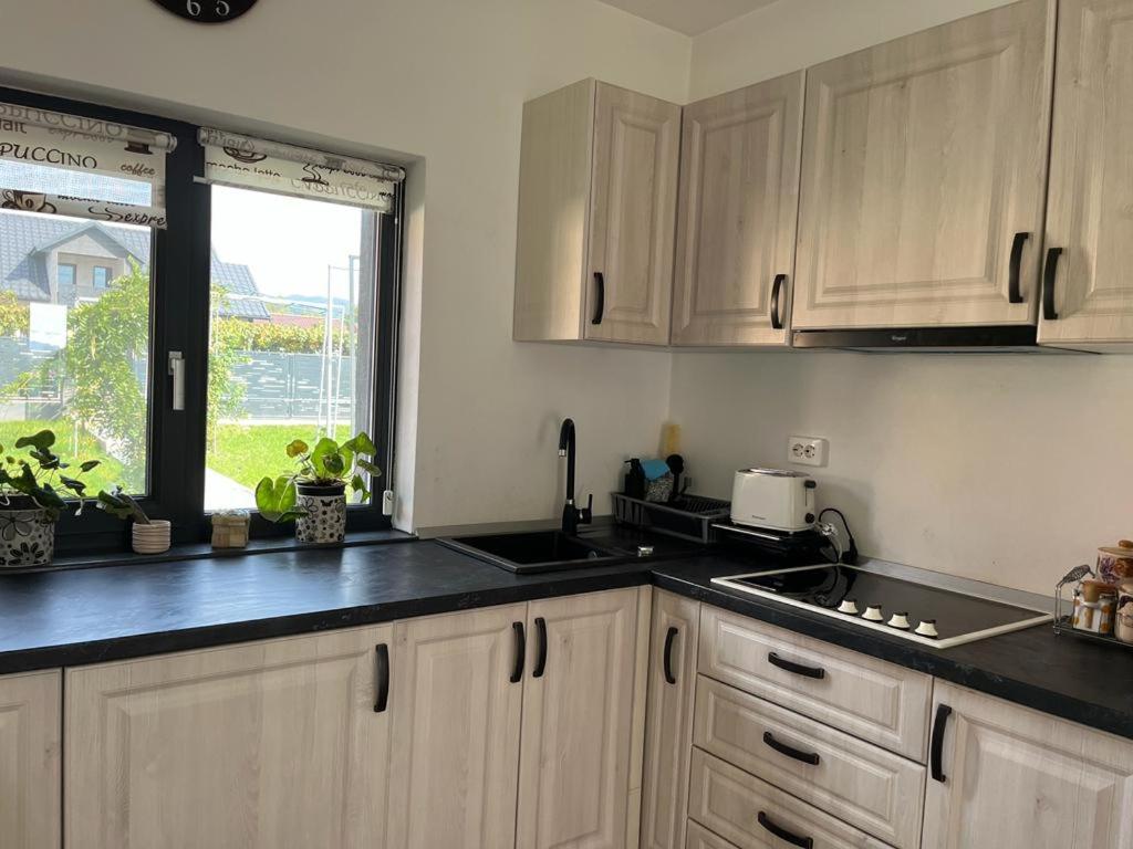a kitchen with white cabinets and a window and a sink at Mimi house in Baia de Fier