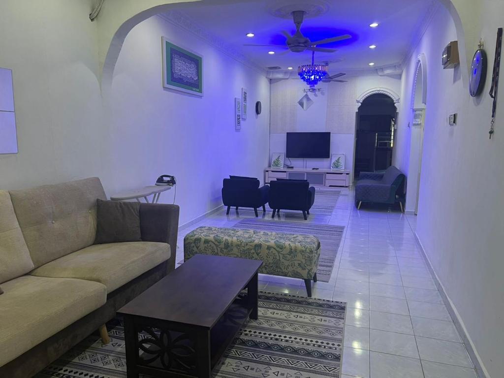 uma sala de estar com um sofá e uma mesa em Nilai Bronizam Homestay em Nilai