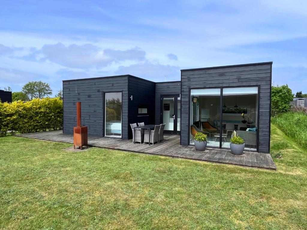 una casa modular negra con patio trasero en Nieuw Noorderland op Terschelling, en Midsland