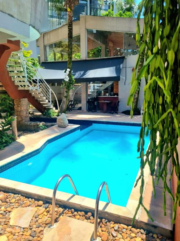 a swimming pool in front of a building at Vila Jabutis in Guarujá