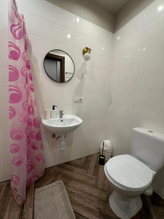 y baño con aseo, lavabo y espejo. en RVR Smart Apartments Riga with Self Check-In, en Riga