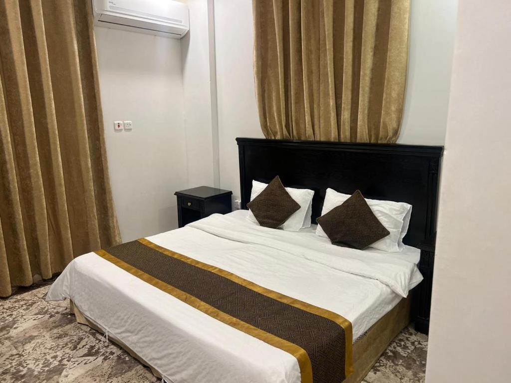 ein Schlafzimmer mit einem großen weißen Bett mit zwei Kissen in der Unterkunft Al Joud Palace Residential Units in Abha