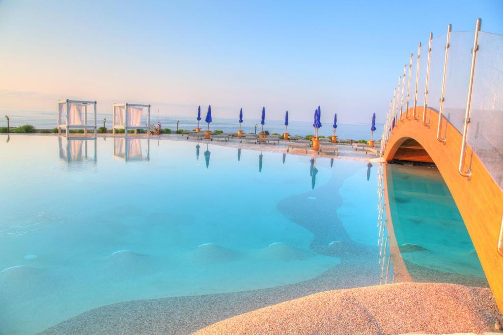 una piscina con acqua blu e un ponte di 19 Summer Suites a Santa Cesarea Terme